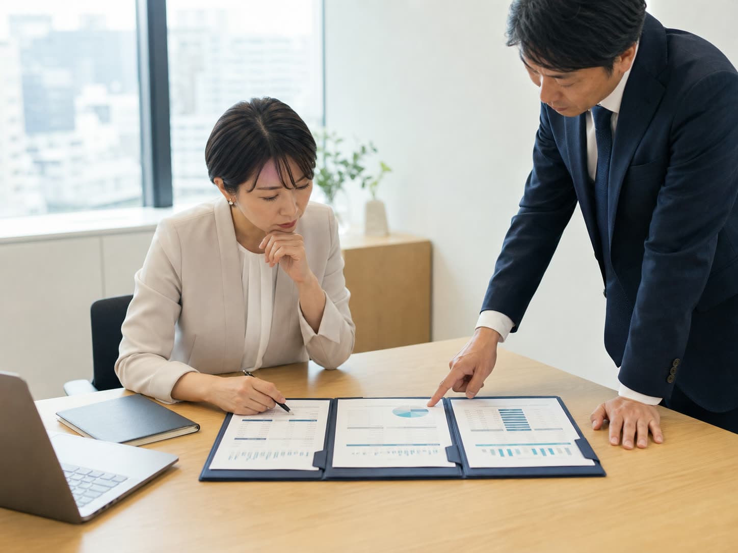 複数の提案資料を同じ机上で比較する発注担当者